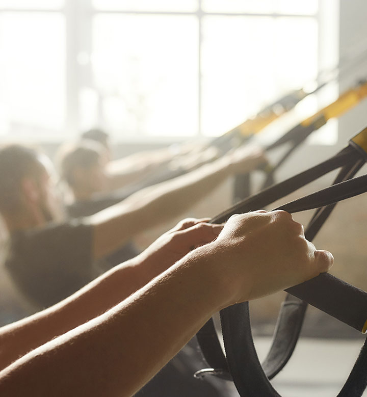 Fitness Franchise showing arms pulling bands for exercise